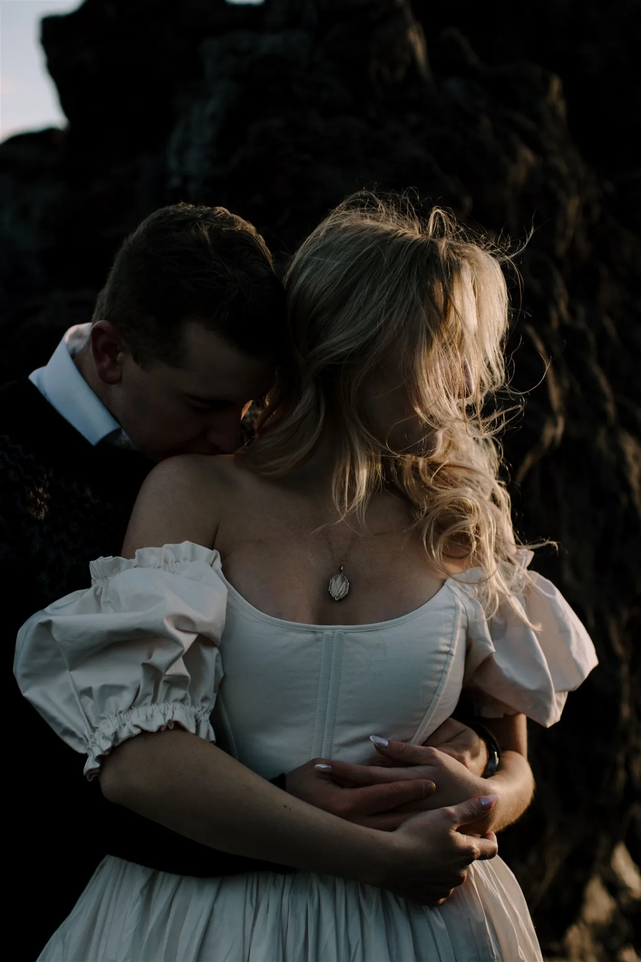 Bride and groom in an intimate pose at sunset, bride wearing a corset dressþ