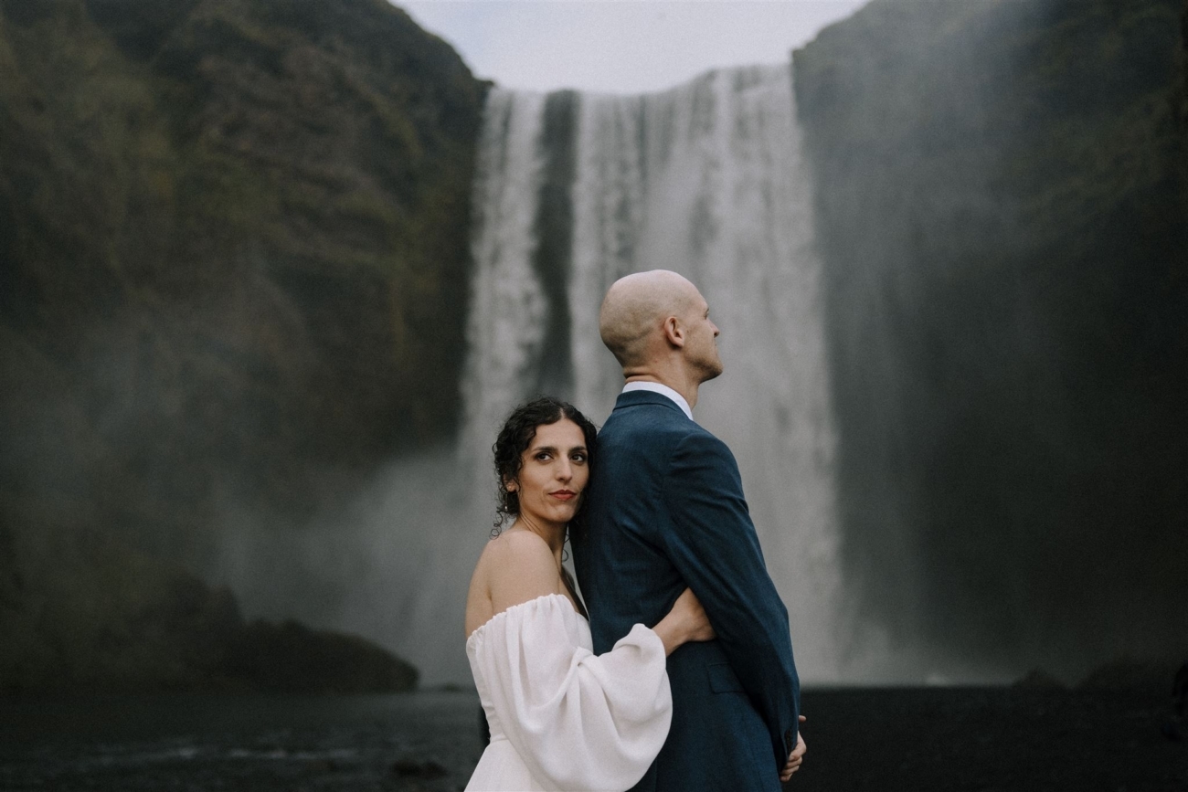 a wedding couple in front of the iconic Skógarfoss waterfall