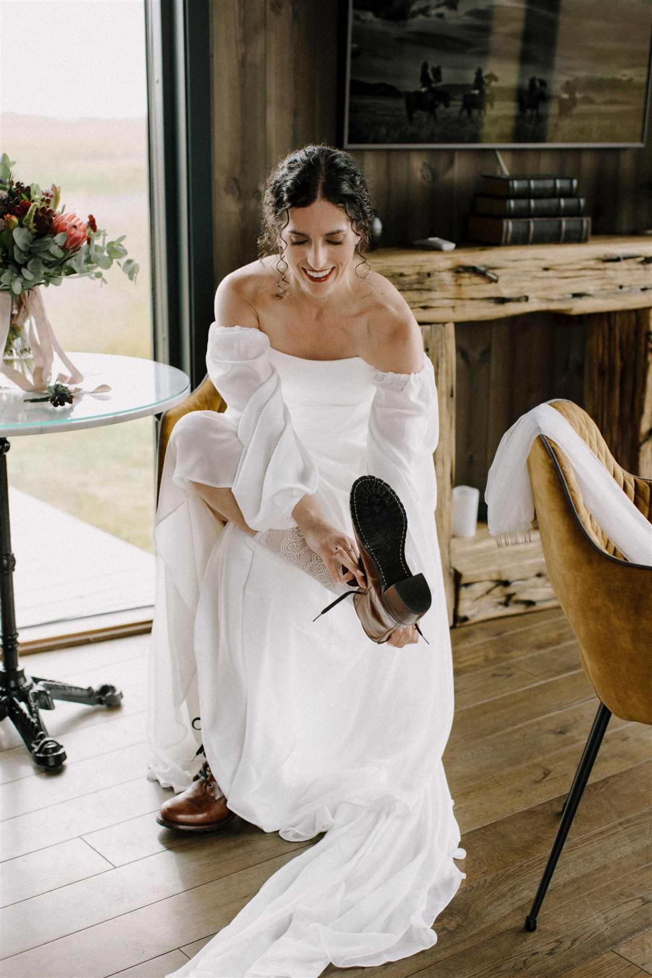 A bride puts on her leather boots wearing her wedding dress as she gets ready for her Iceland elopement on the south coast.