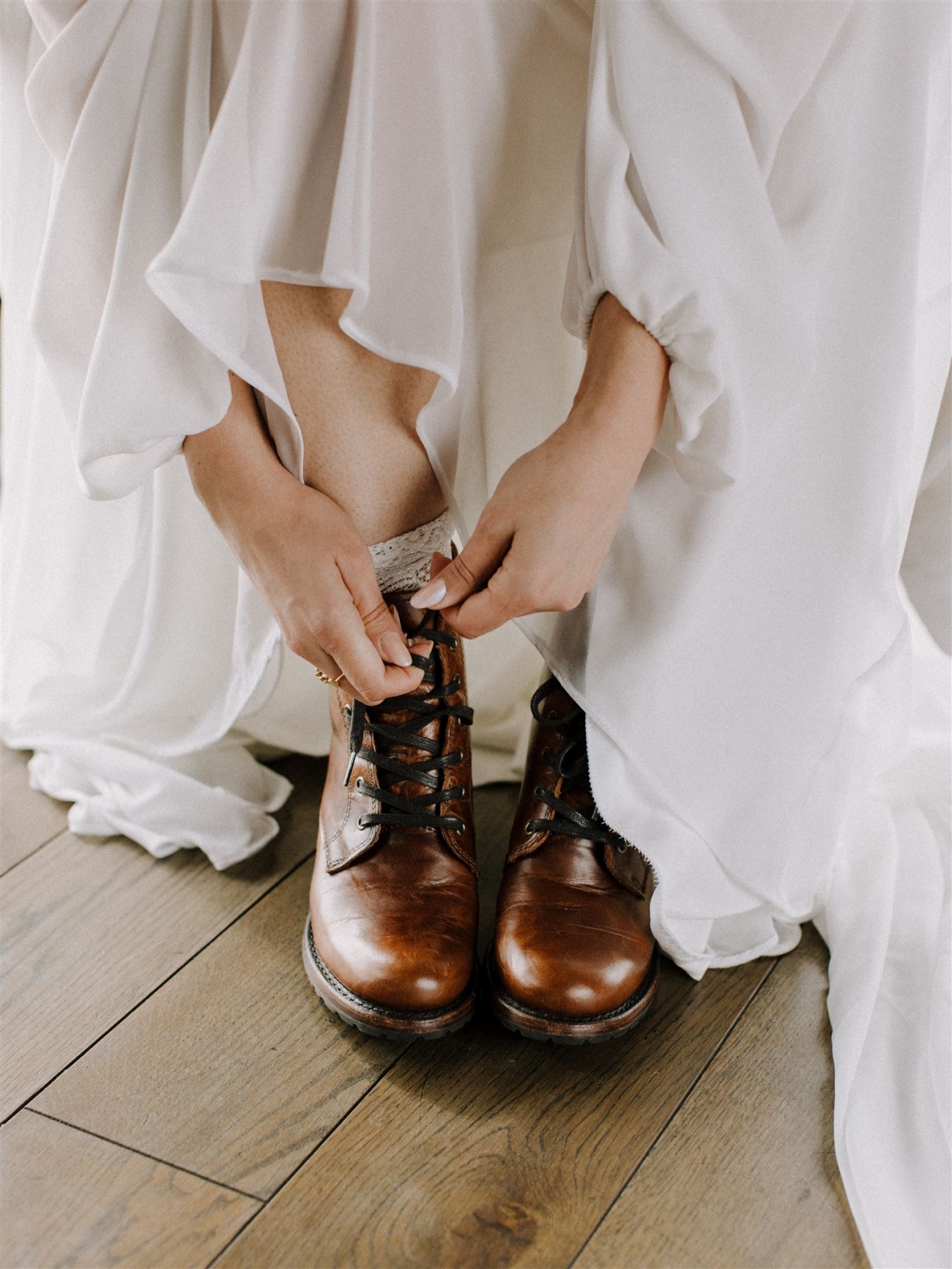 A bride laces up her leather boots on her wedding day in Iceland - before she starts the hike to here secret ceremony spot.