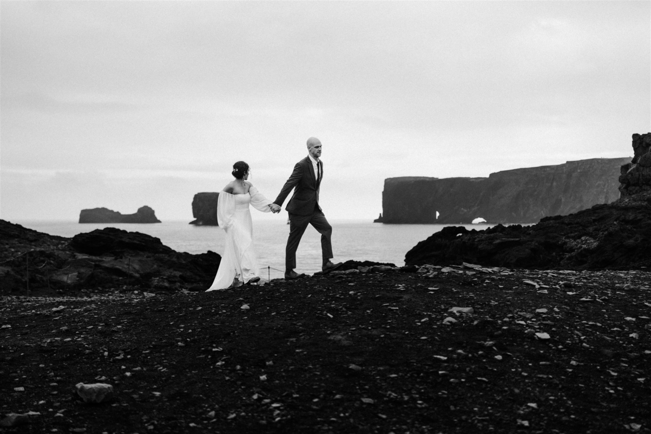 A bride and groom adventuring among the sea cliffs of the south coast of Iceland on their elopement day.