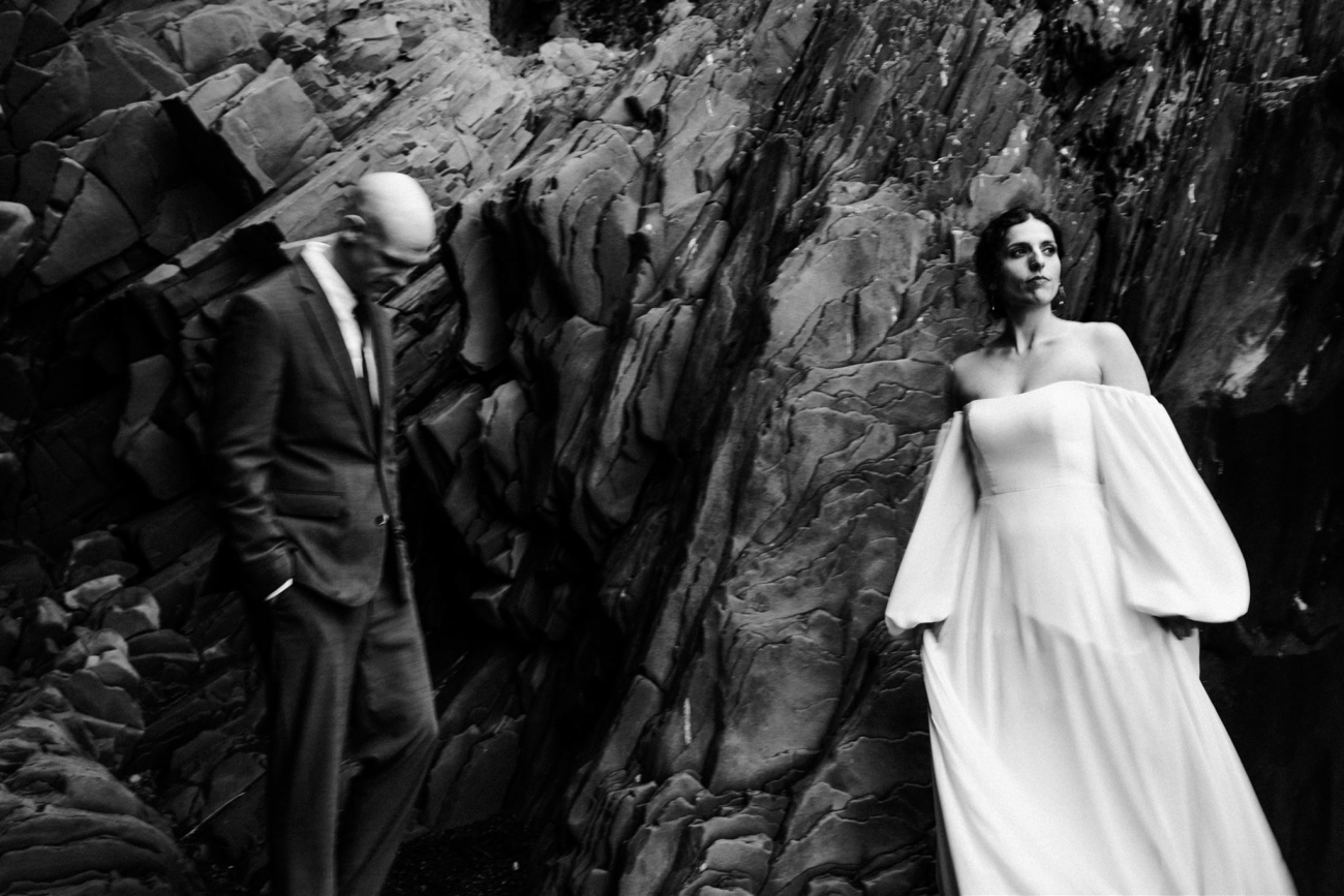 A dramatic portrait with movement, blur and feelings underneath the basalt walls of Reynisfjara black sand beach while eloping in Iceland.