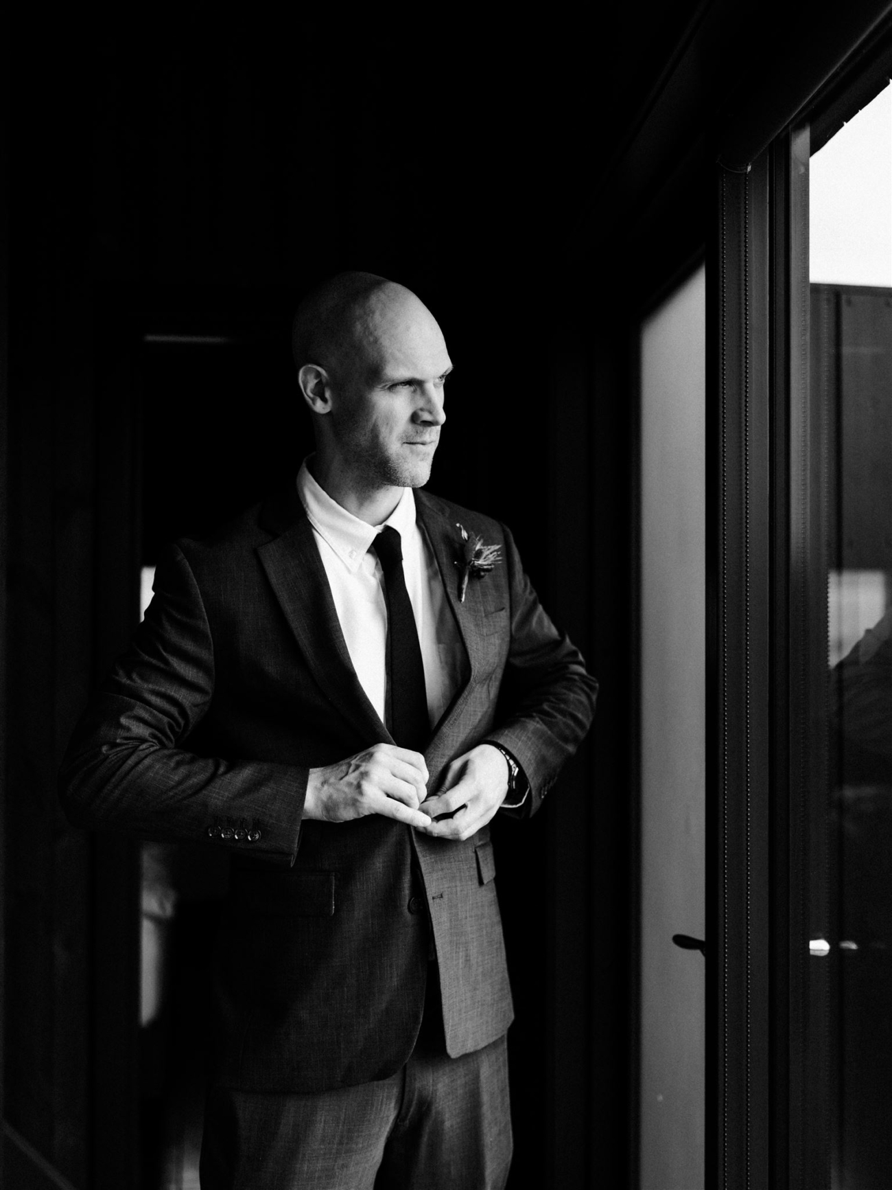 A groom portrait in black and white - getting ready in a cabin during an Iceland elopement.