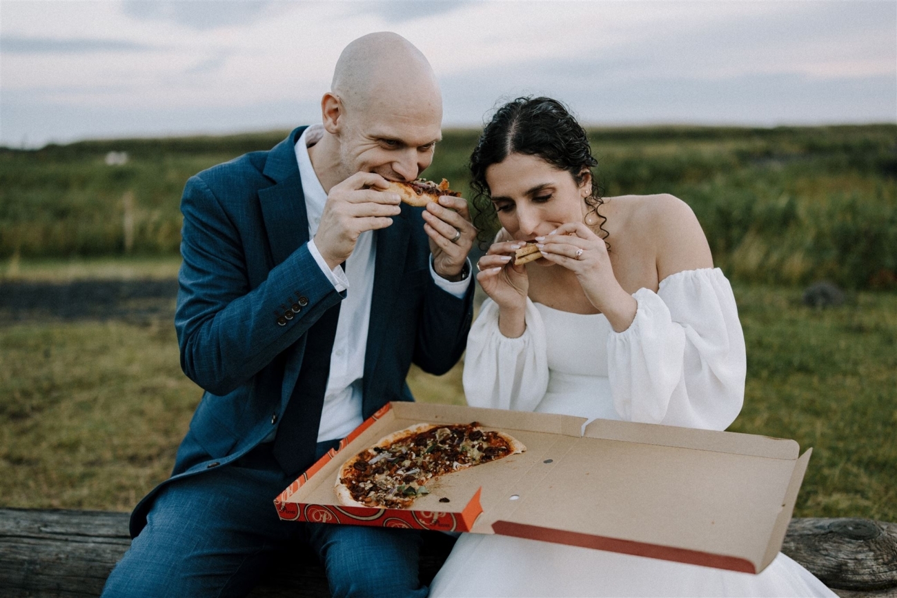 A bride and groom enjoy a pizza instead of a fancy dinner on their elopement day in Iceland.