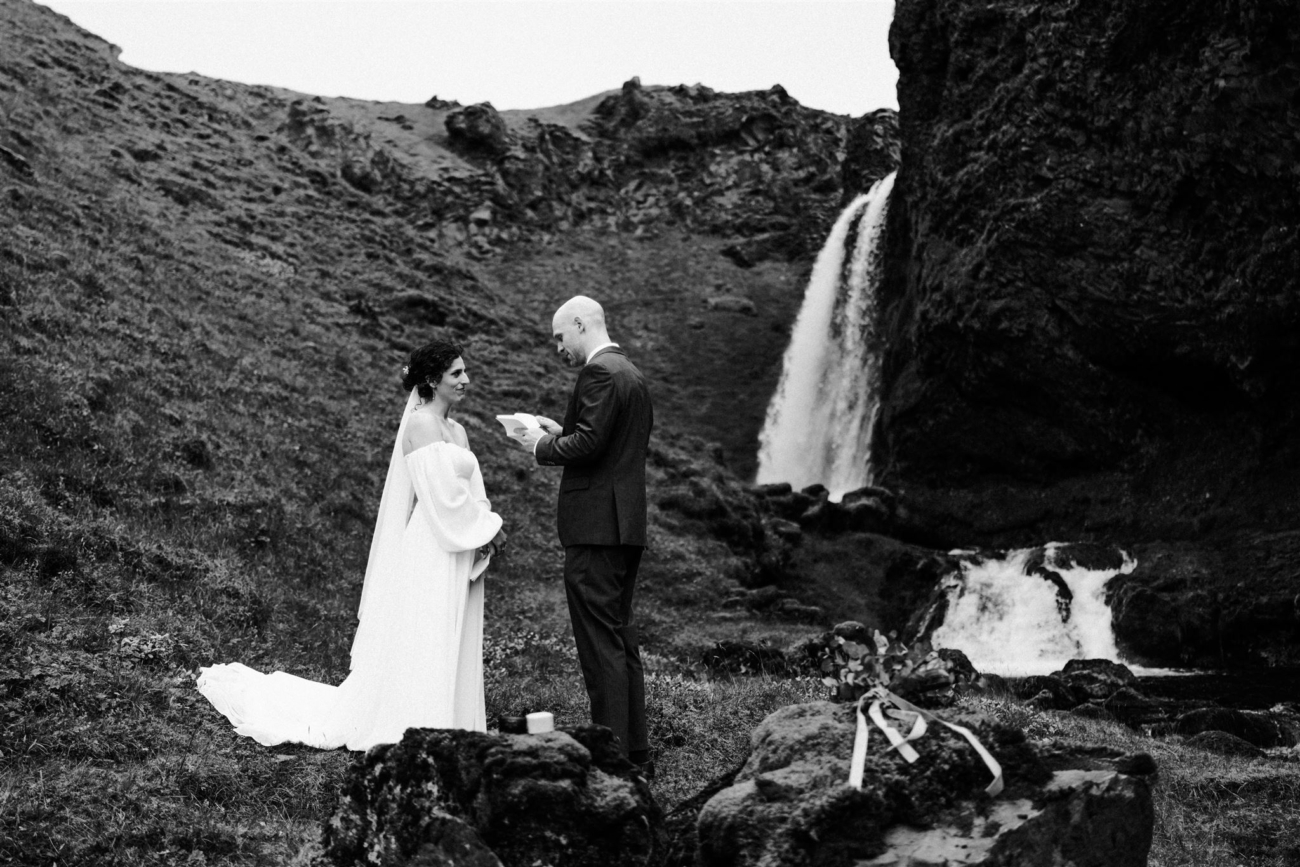 A bride and groom read private vows to each other during their Iceland elopement ceremony.