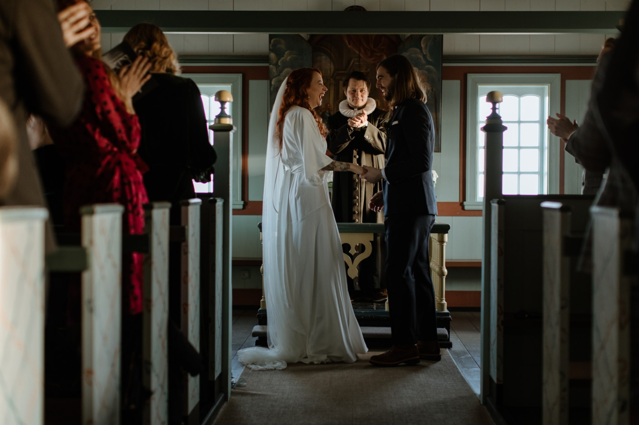 A wedding ceremony in the dimly lit Búðakirkja church.