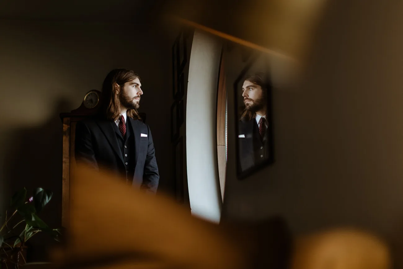 Groom looking out the window during getting ready