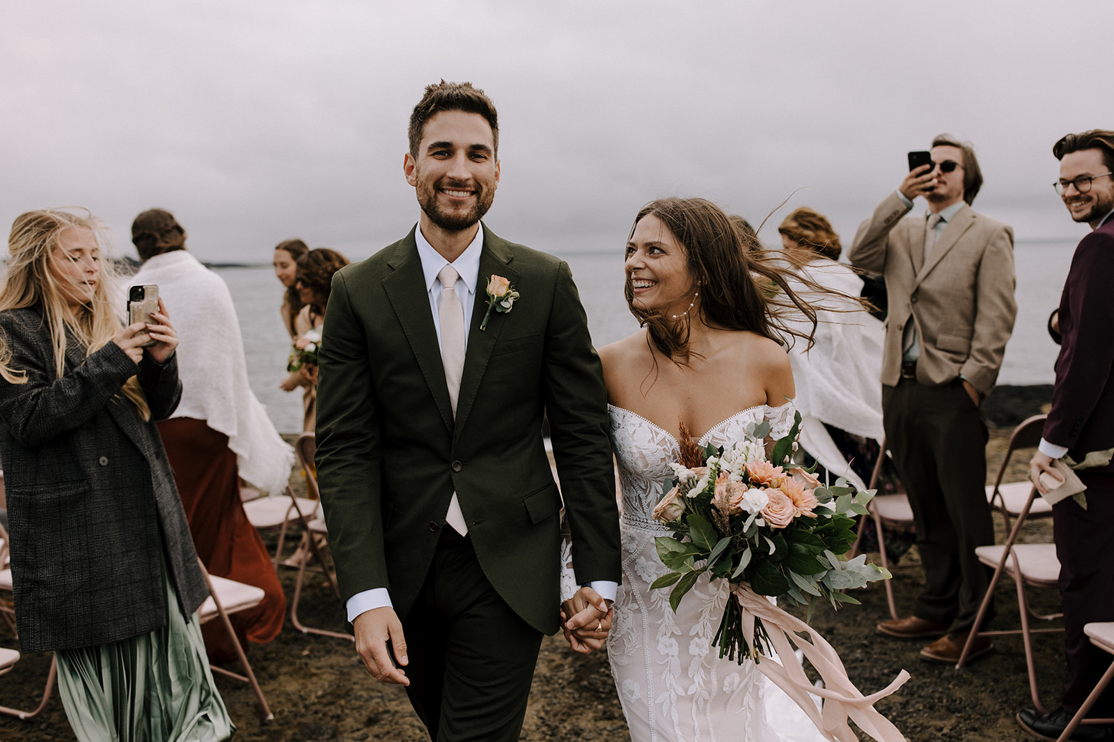A couple walks their wild aisle after their cliff side wedding ceremony in Iceland.