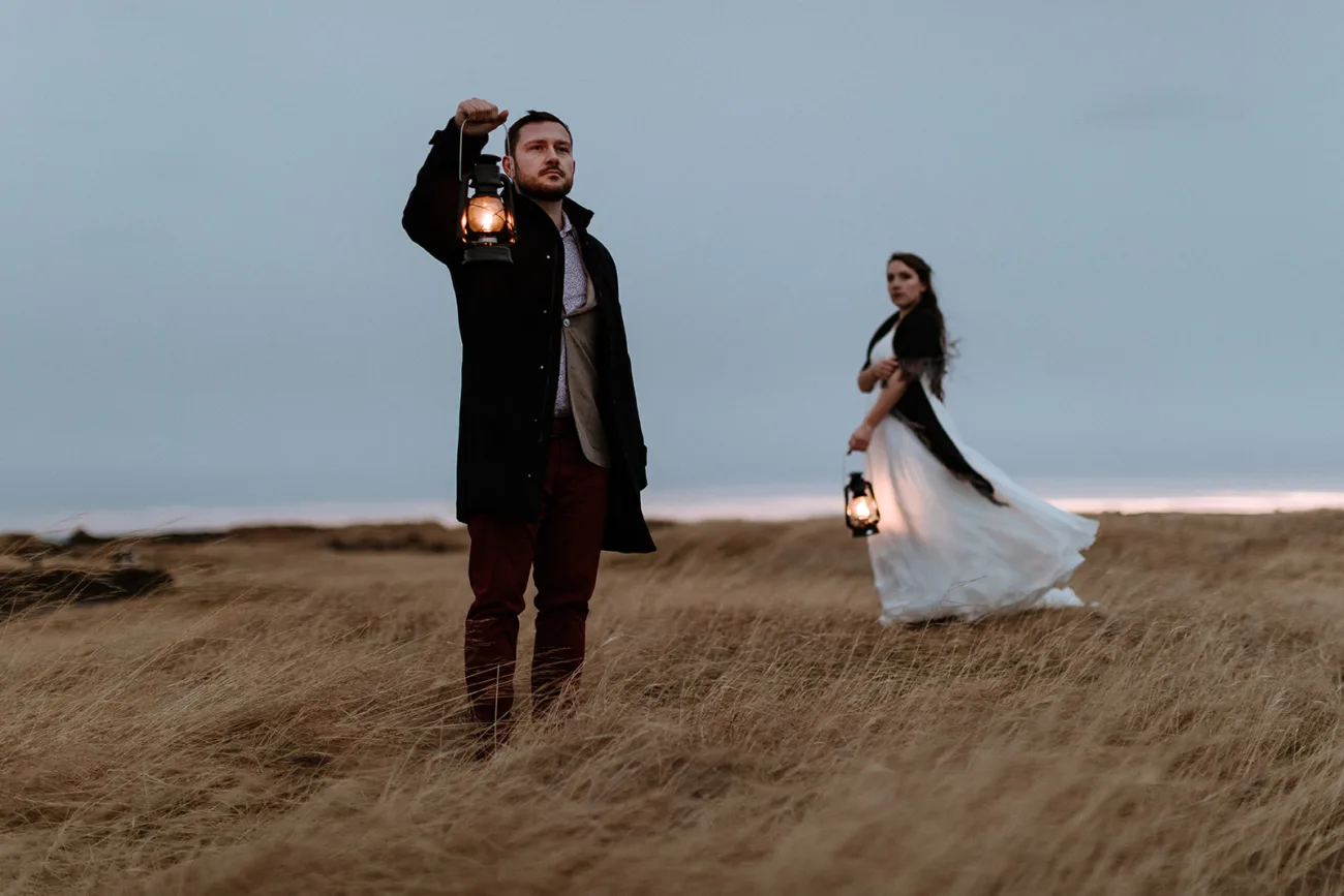 Bride and groom, holding lanterns in a yellow field