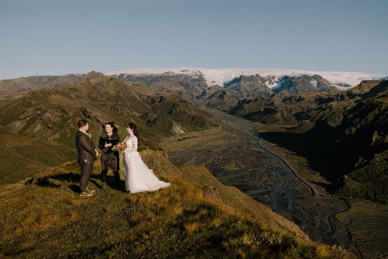 A wedding ceremony held on top of a mountain with stunning views of mountain ranges and glaciers in the background.