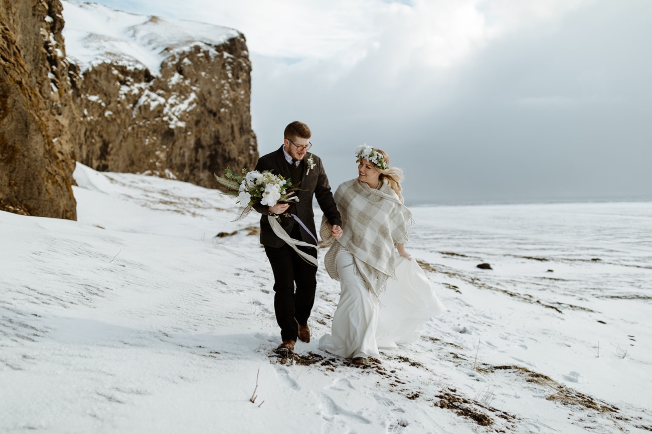 Couple hikes through frozen landscapes in the middle of winter but with big smiles on their faces.
