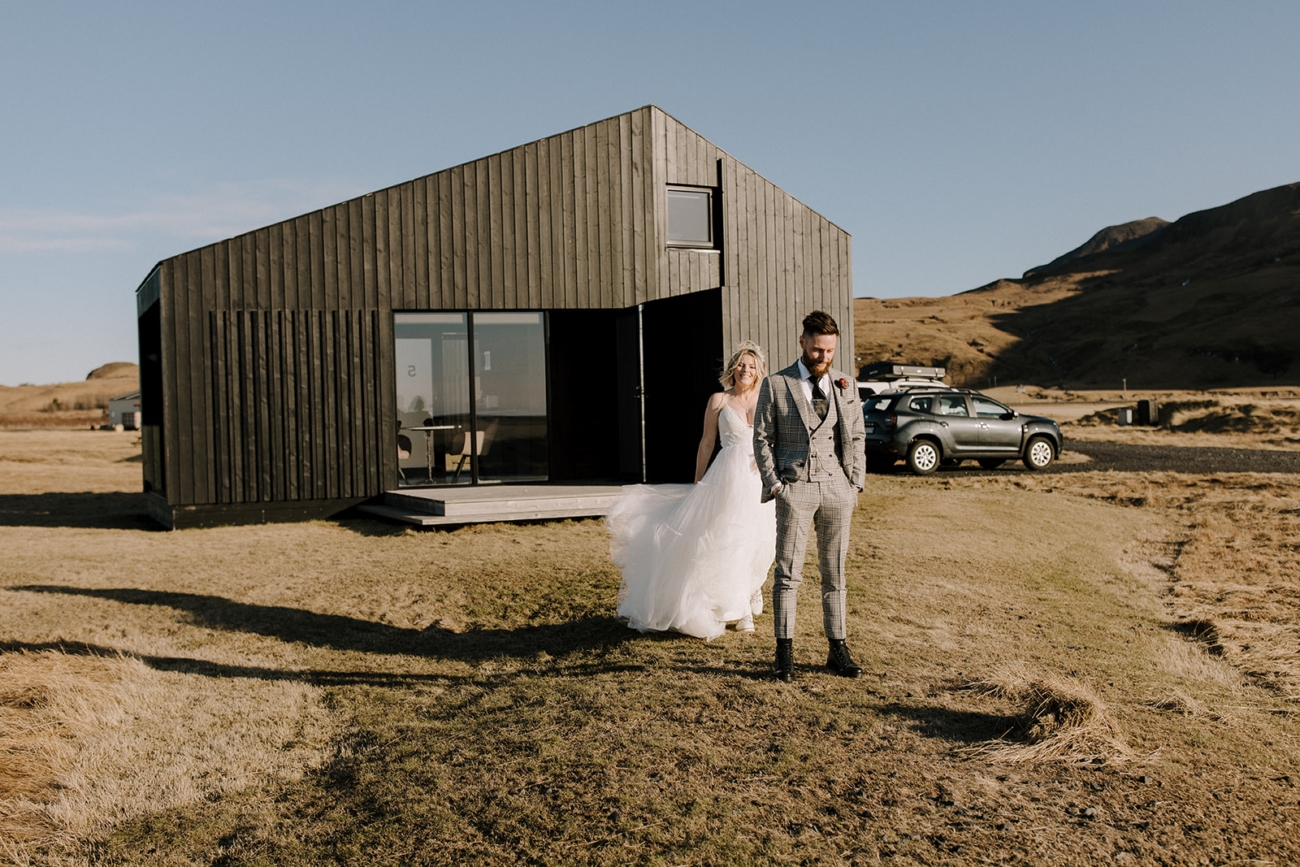 Picturesque black cabins nestled under the mountains and waterfalls of south Iceland.