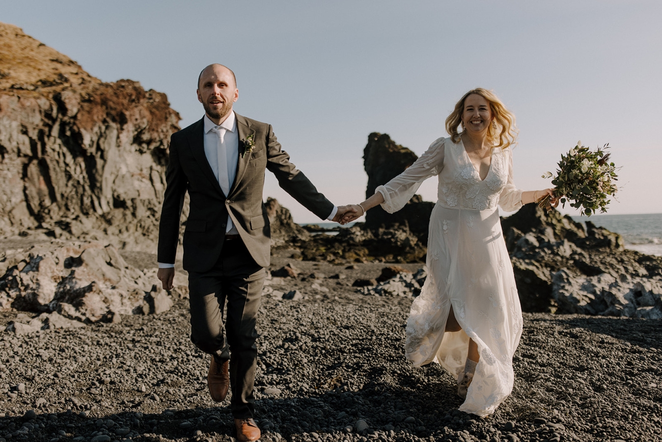Running on a black sand beach during your elopement.