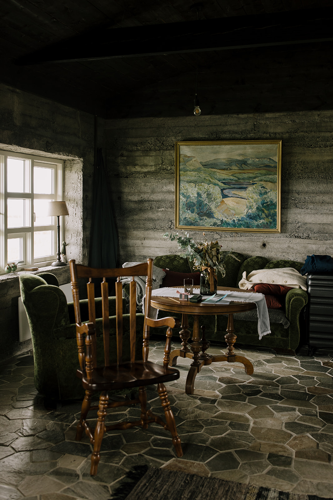 Moody cabin interiors. Old wooden furnitures, concrete walls and stone tiles. 