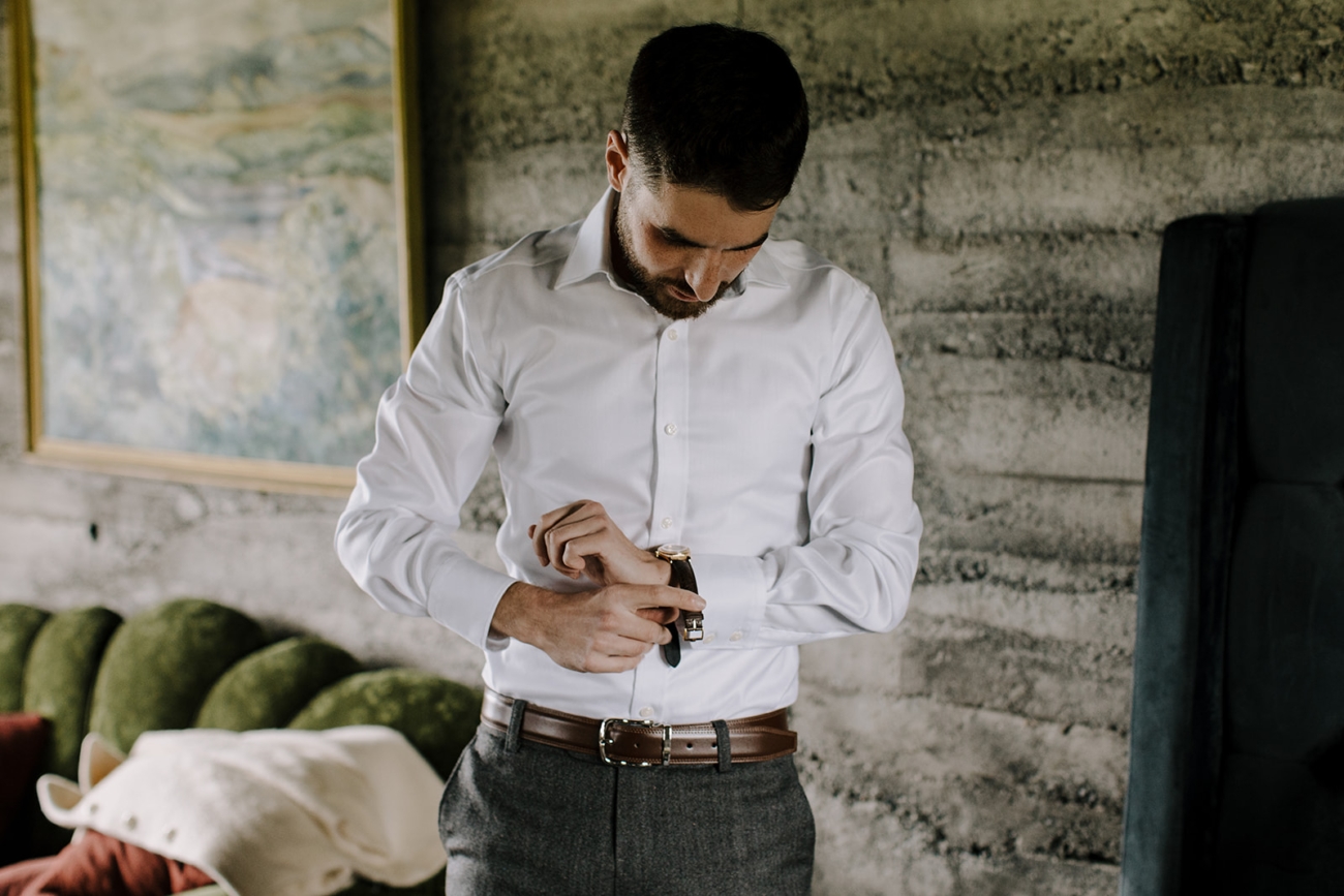A groom gets ready in a cozy cabin in Iceland.