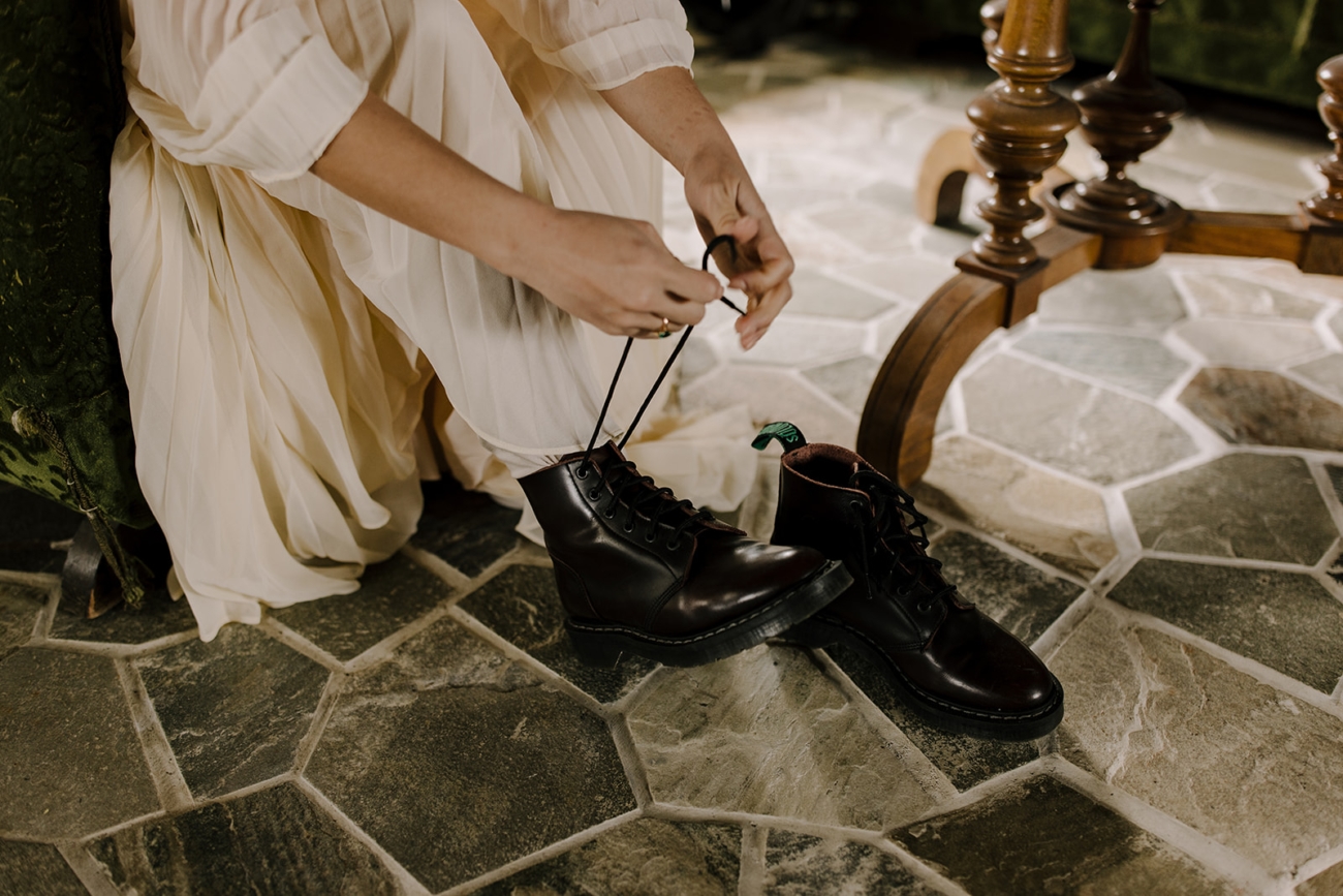 A bride laces up her hiking boots before an adventurous mountain elopement in Iceland.