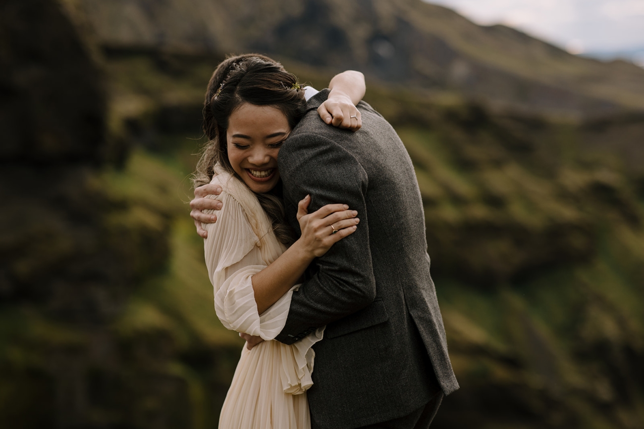 A couple embrace and laugh as the finish their elopement ceremony in Iceland. 