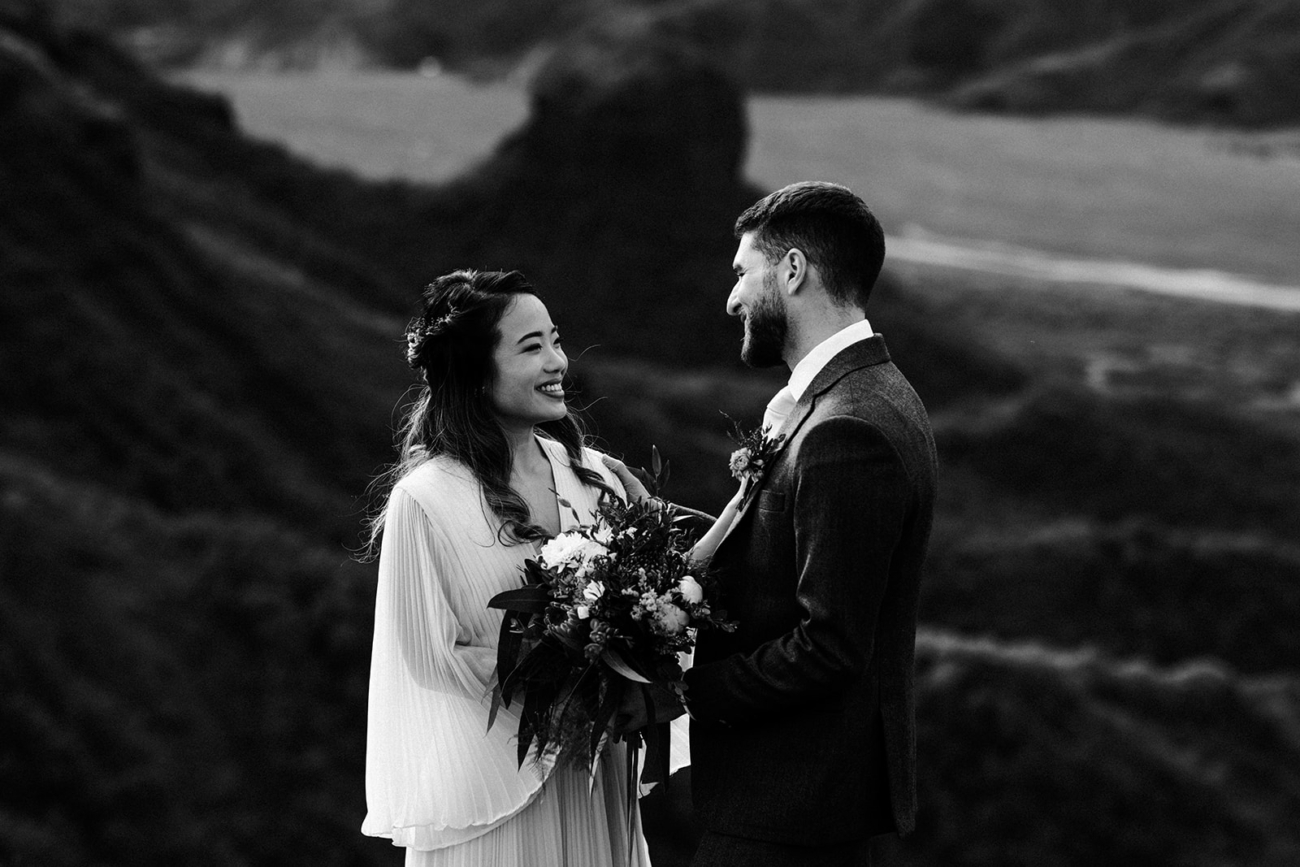 A bride holding a wild bouquet at a personal vow reading.