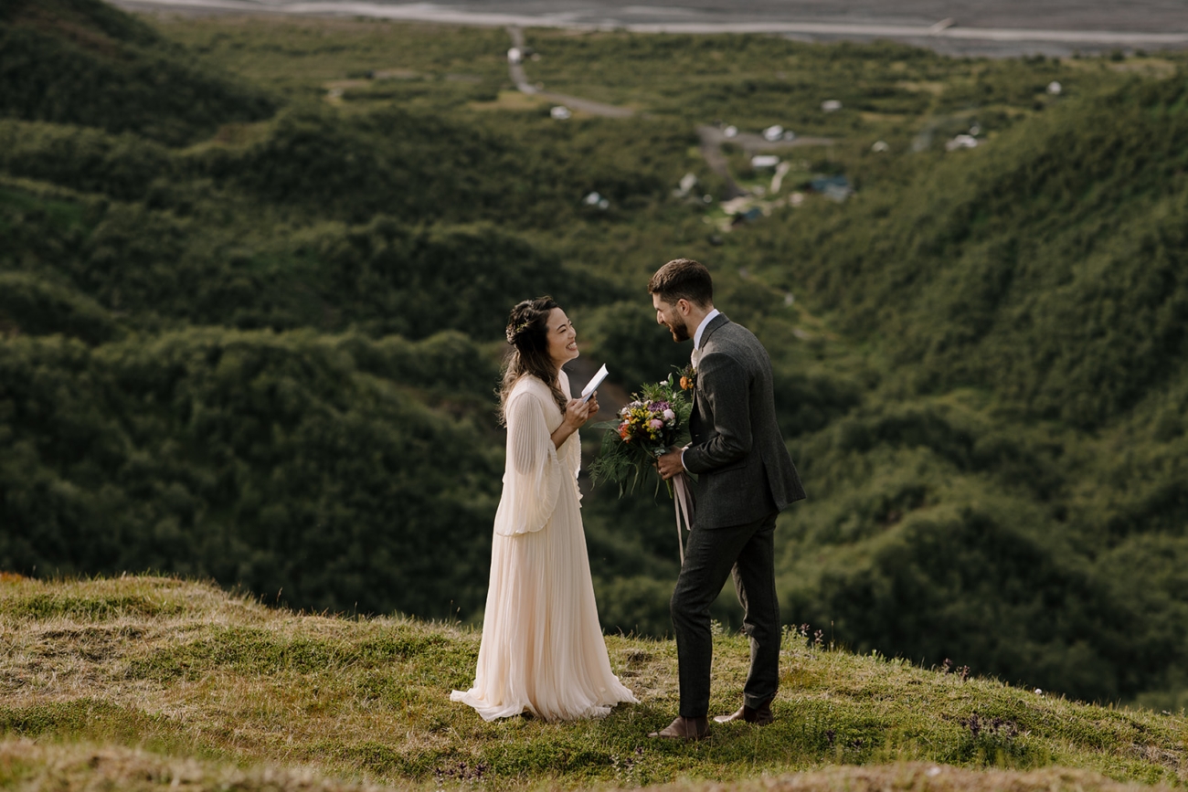 A couple laughing at a lookout over a sprawling birch forest in Iceland. 