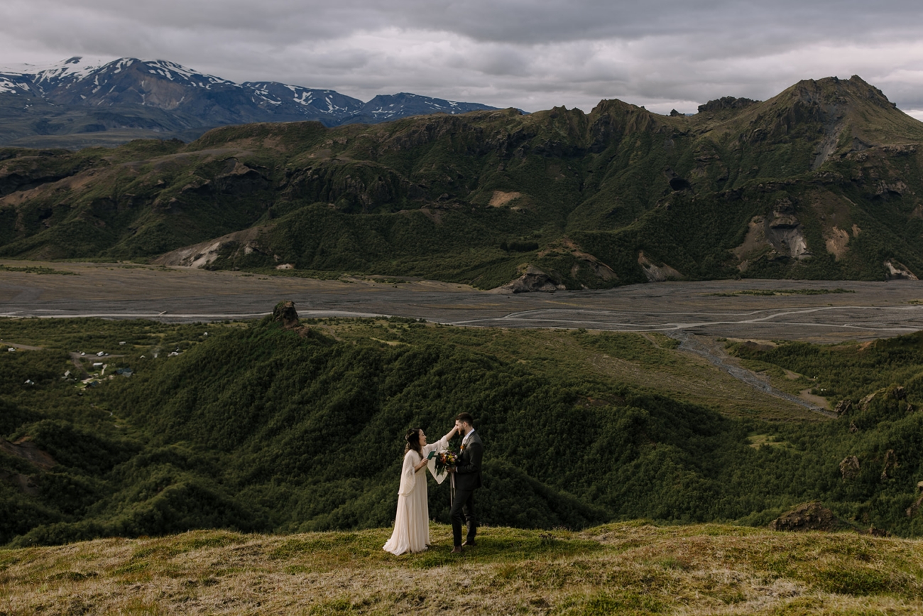 A bride wipes away a tear as she reads her vows to him.