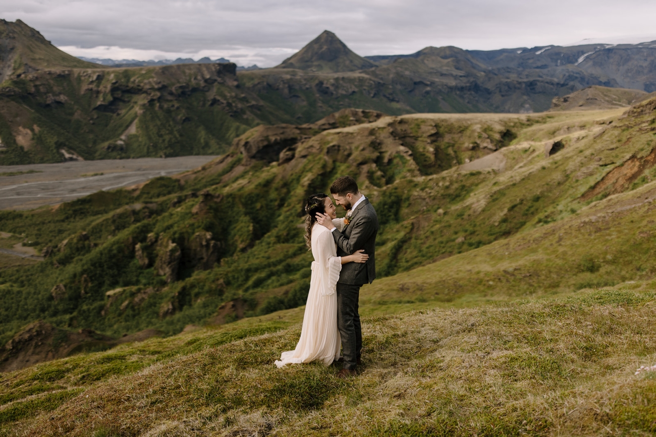 A couple in a warm embrace with breathtaking mountain view in the background.