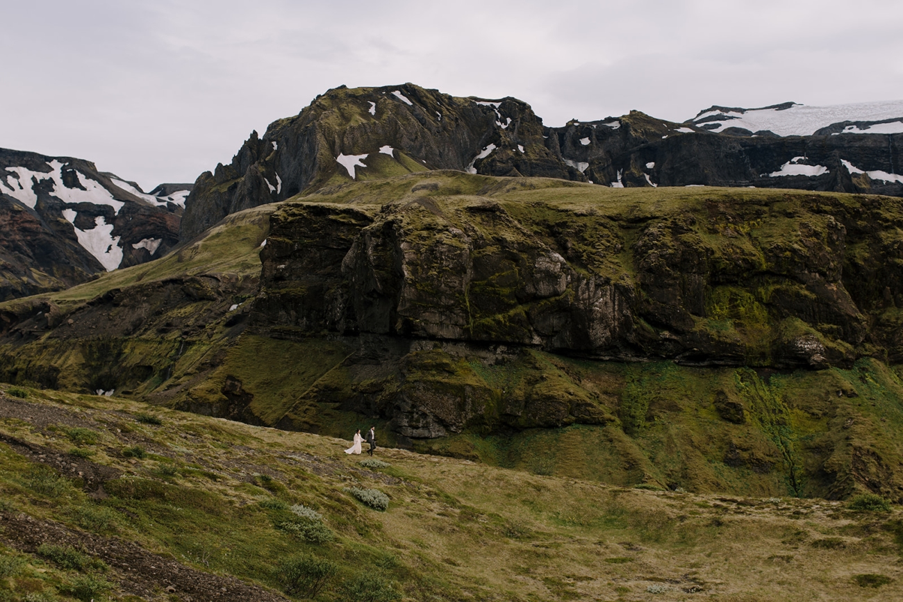 A couple getting lost in vast landscapes with snow covered mountains and glaciers in the background. 