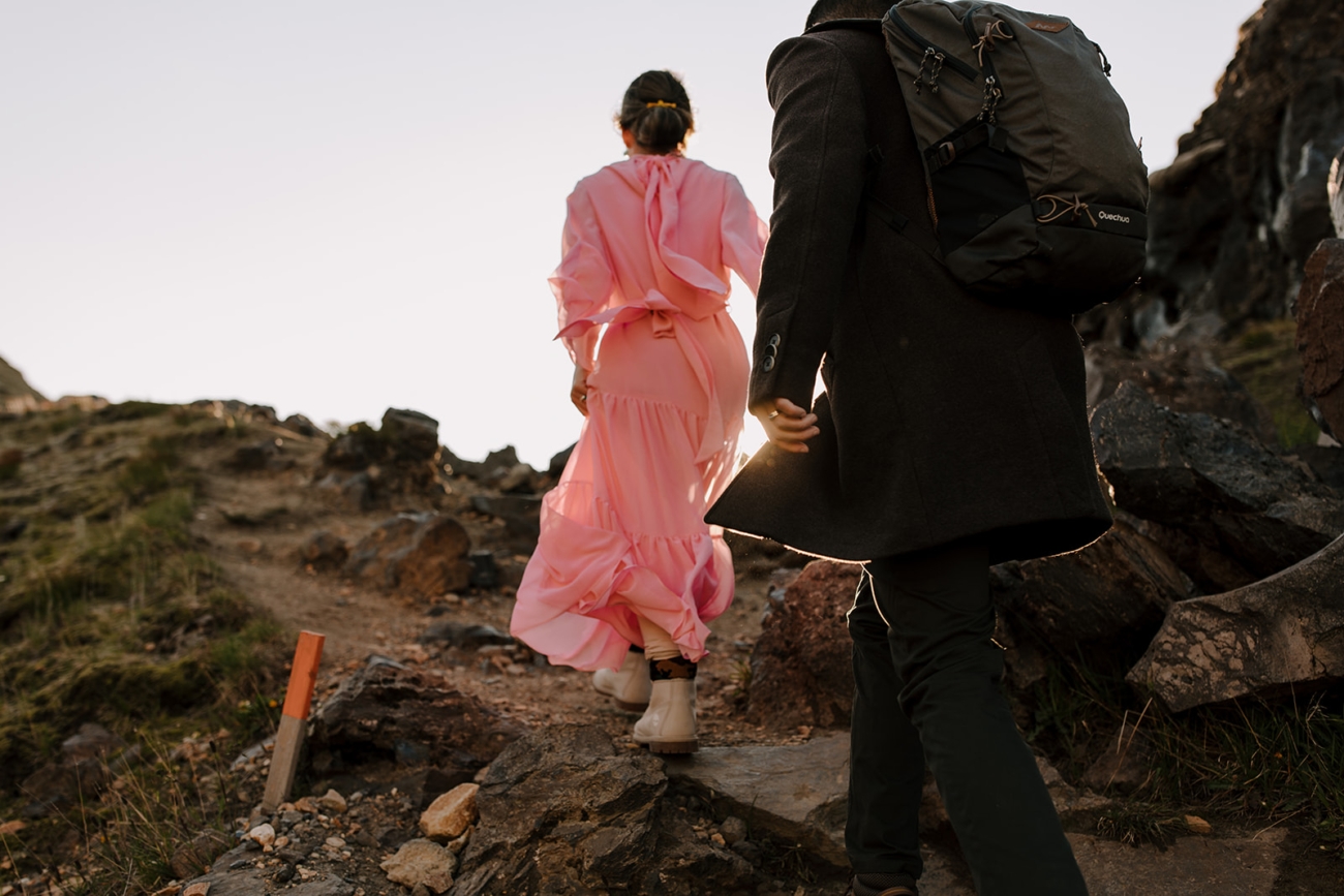 A flowy dress catches the light as the sun sets behind a hill. 