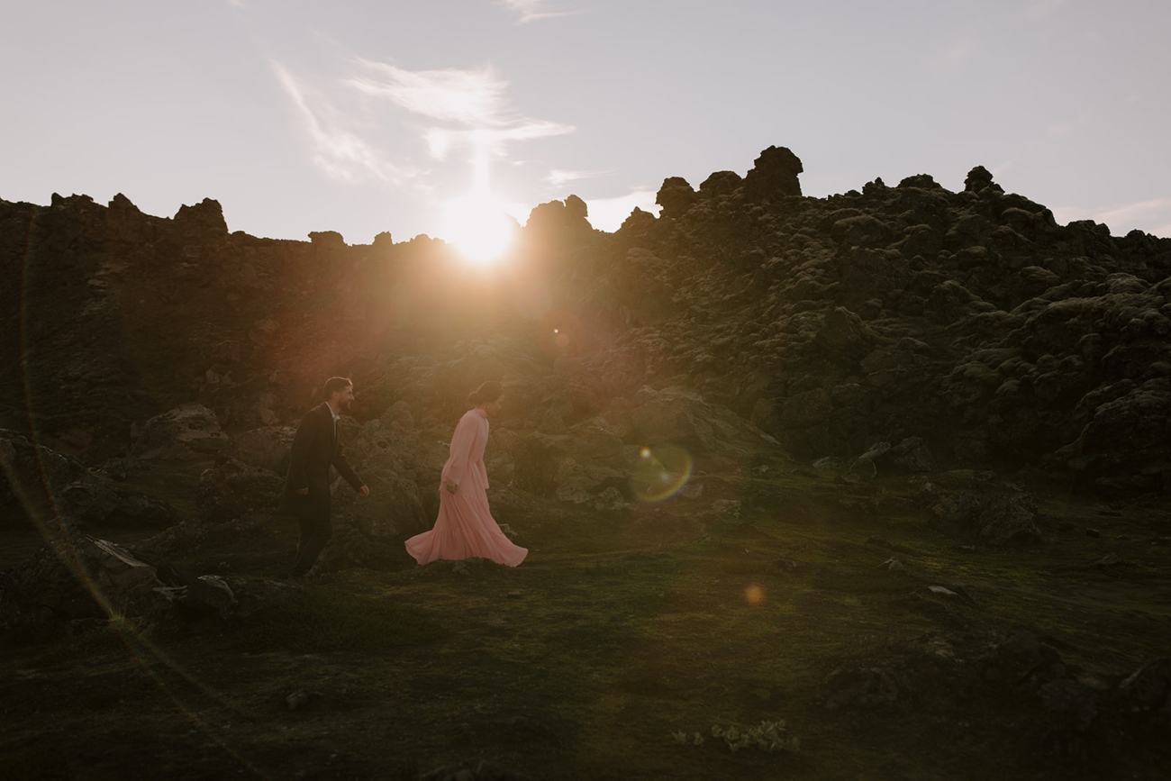 the sun sets behind a tall lava field. 
