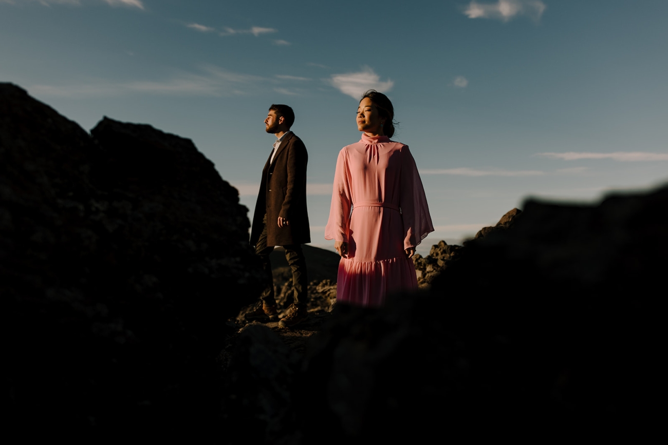 A couple enjoys the last rays of the setting sun in the middle of a lava field in the mountains of Iceland. 