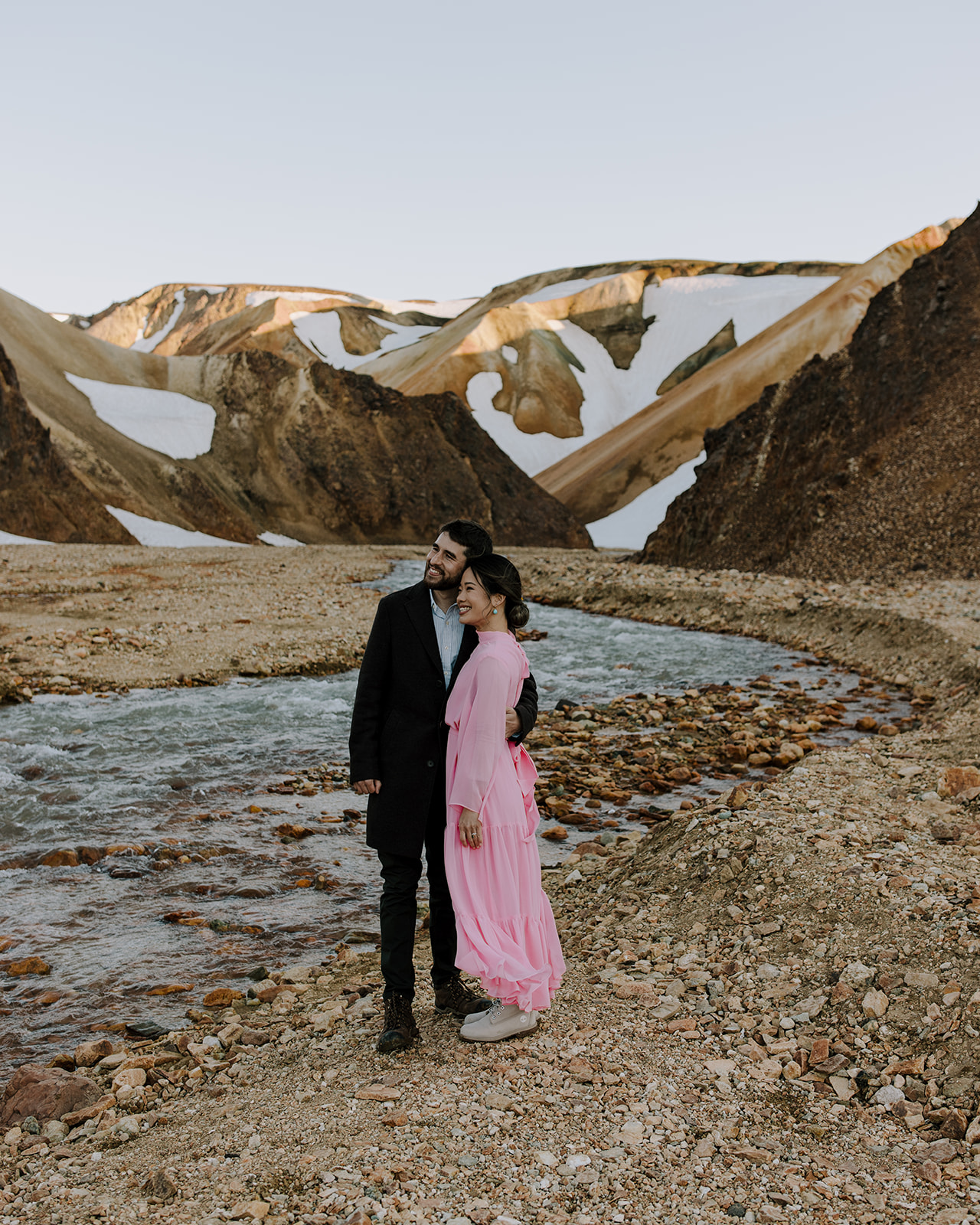 Standing on the banks of a river that rustles through Rhyolite rocks in Landmannalaugar region in Iceland.
