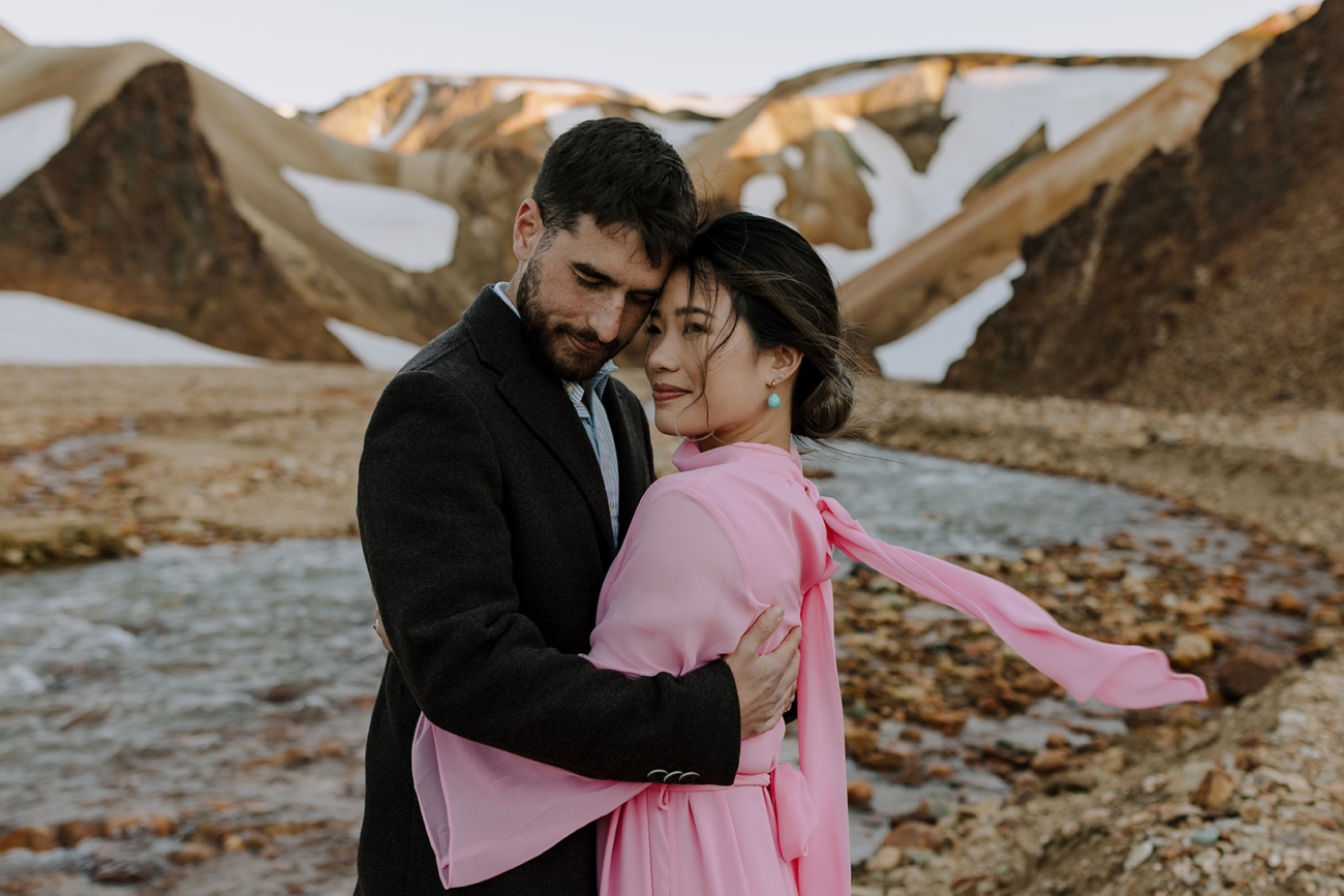 An embrace as the wind sweeps through hair and dresses on an elopement day in Iceland.