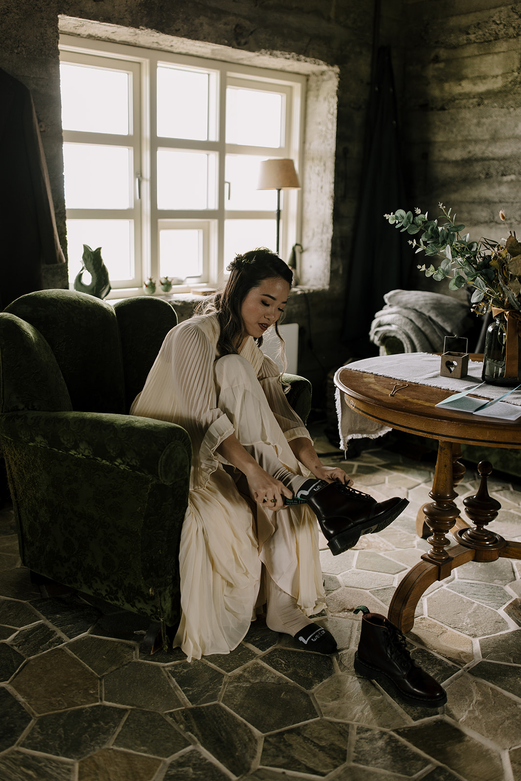 A bride laces up her hiking boots before an adventurous mountain elopement in Iceland.